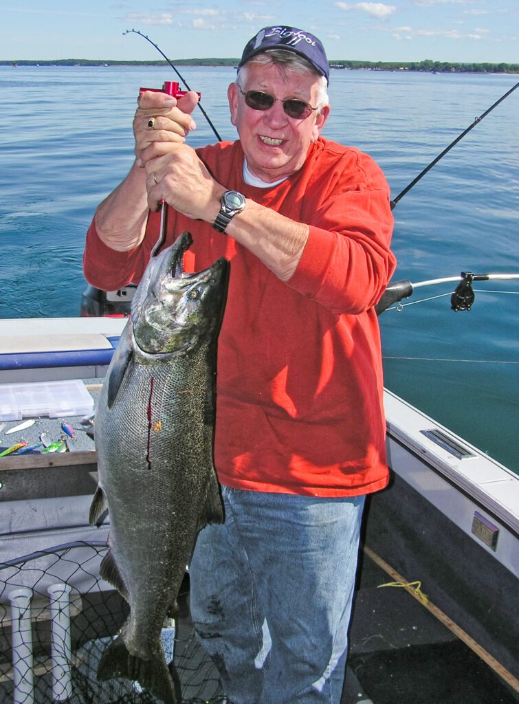 man holding salmon on lake Ontario